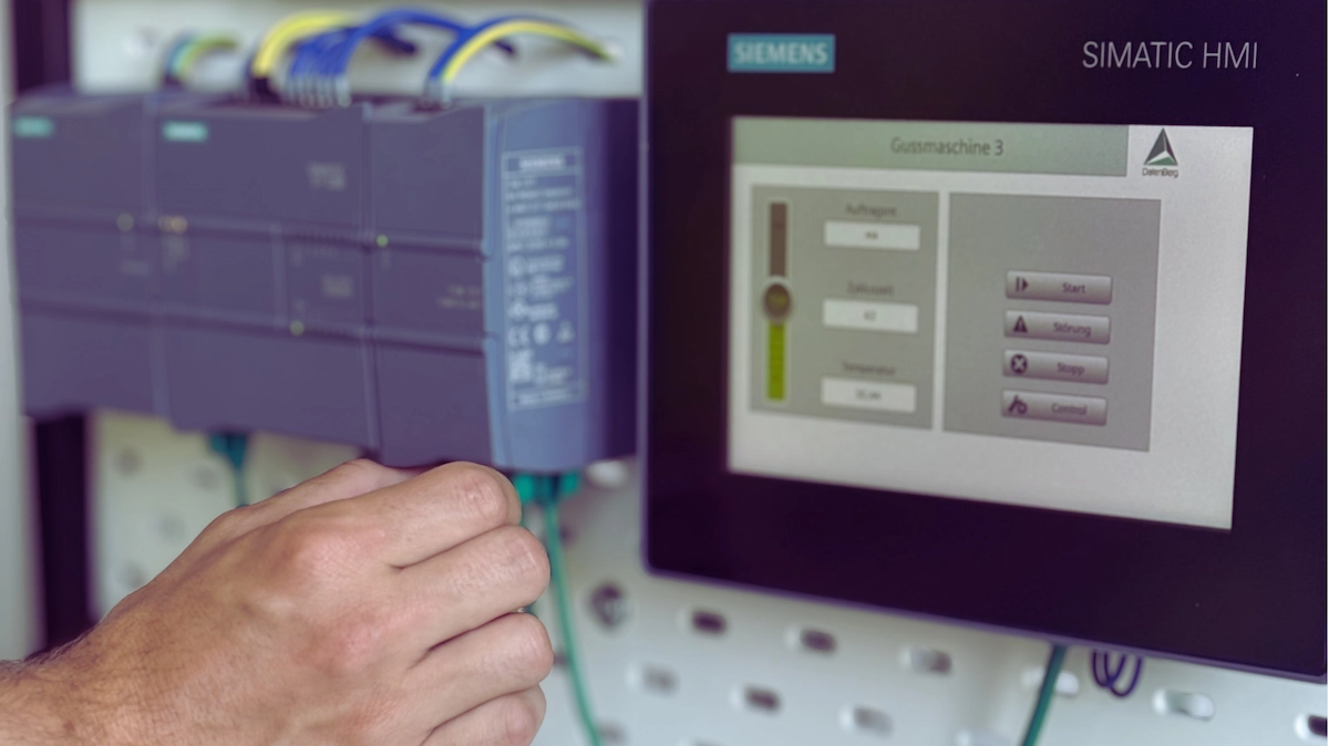 Hand steckt ein Netzwerkkabel an eine Siemens S7-Steuerung, daneben ein SIMATIC HMI Bedienpanel