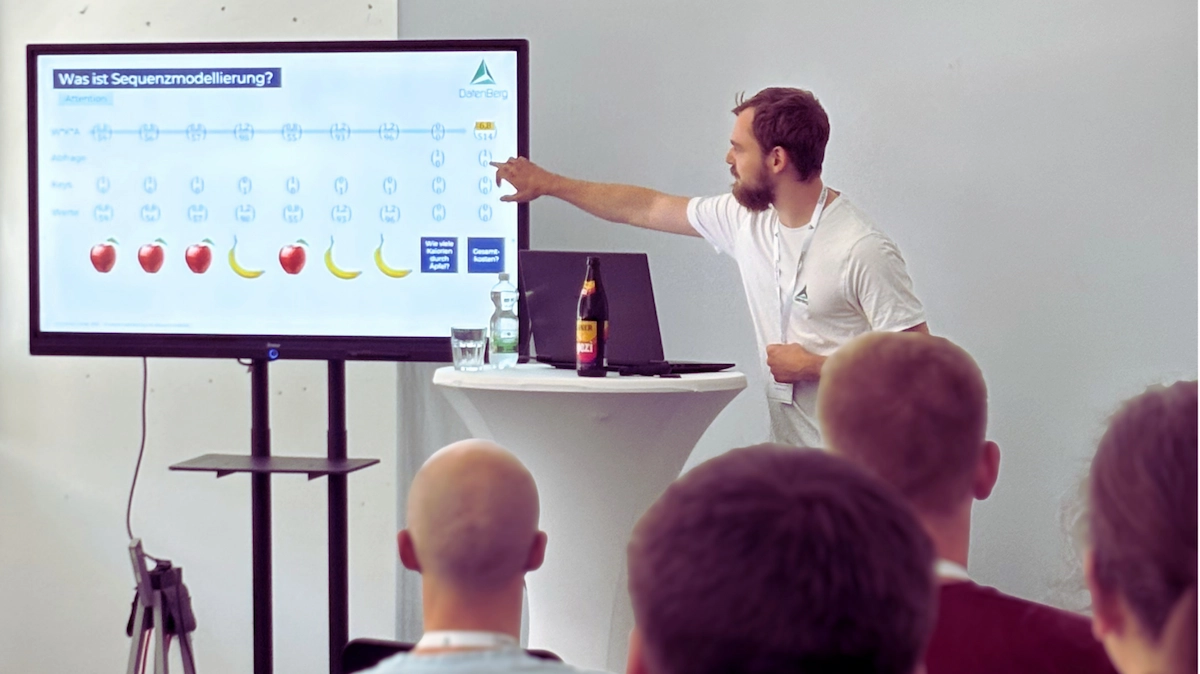 Referent erklärt Sequenzmodellierung an einem Bildschirm vor Teilnehmenden eines Workshops